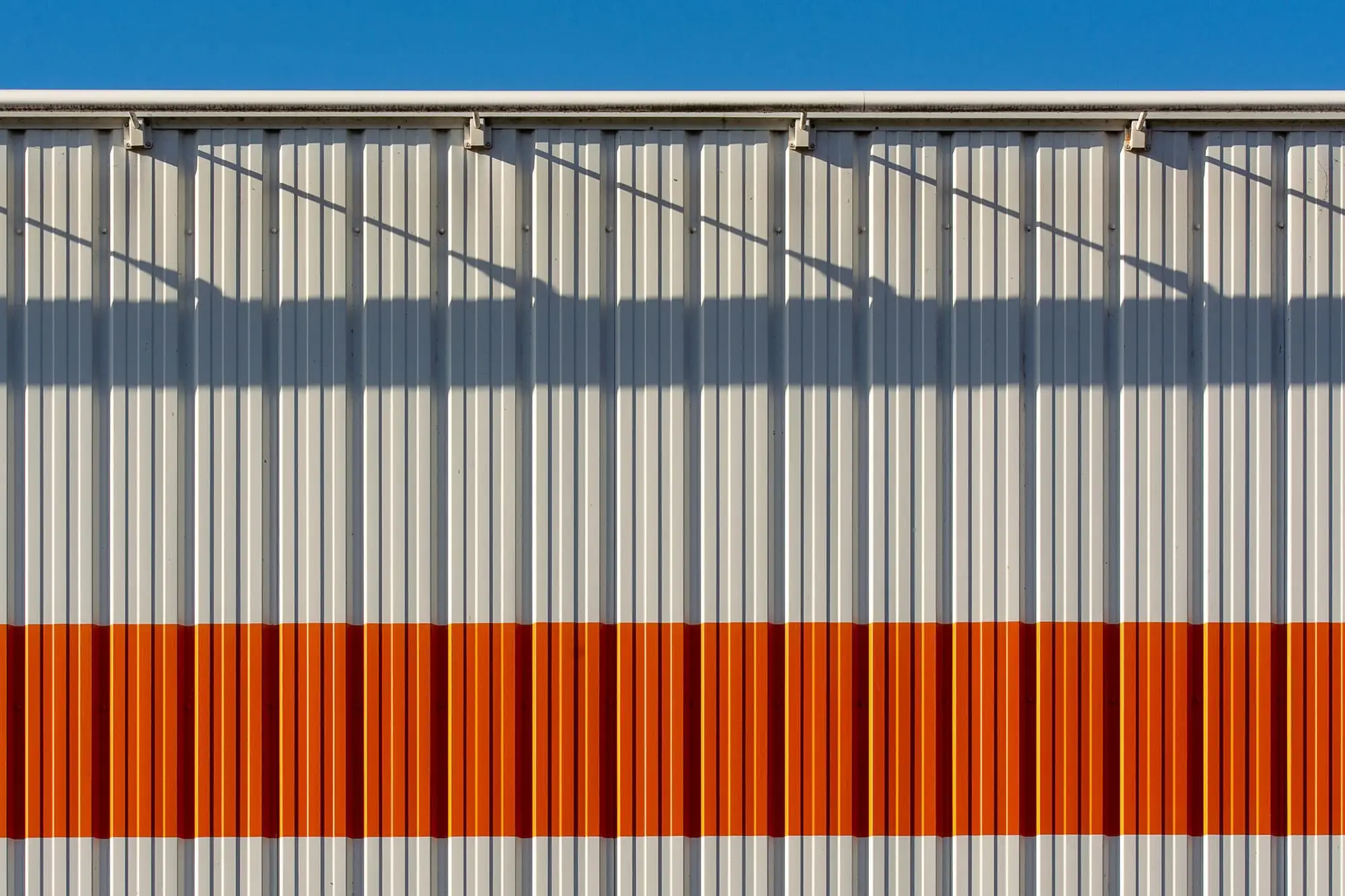 Facade på en erhvervsbygning i grå og orange metalplader