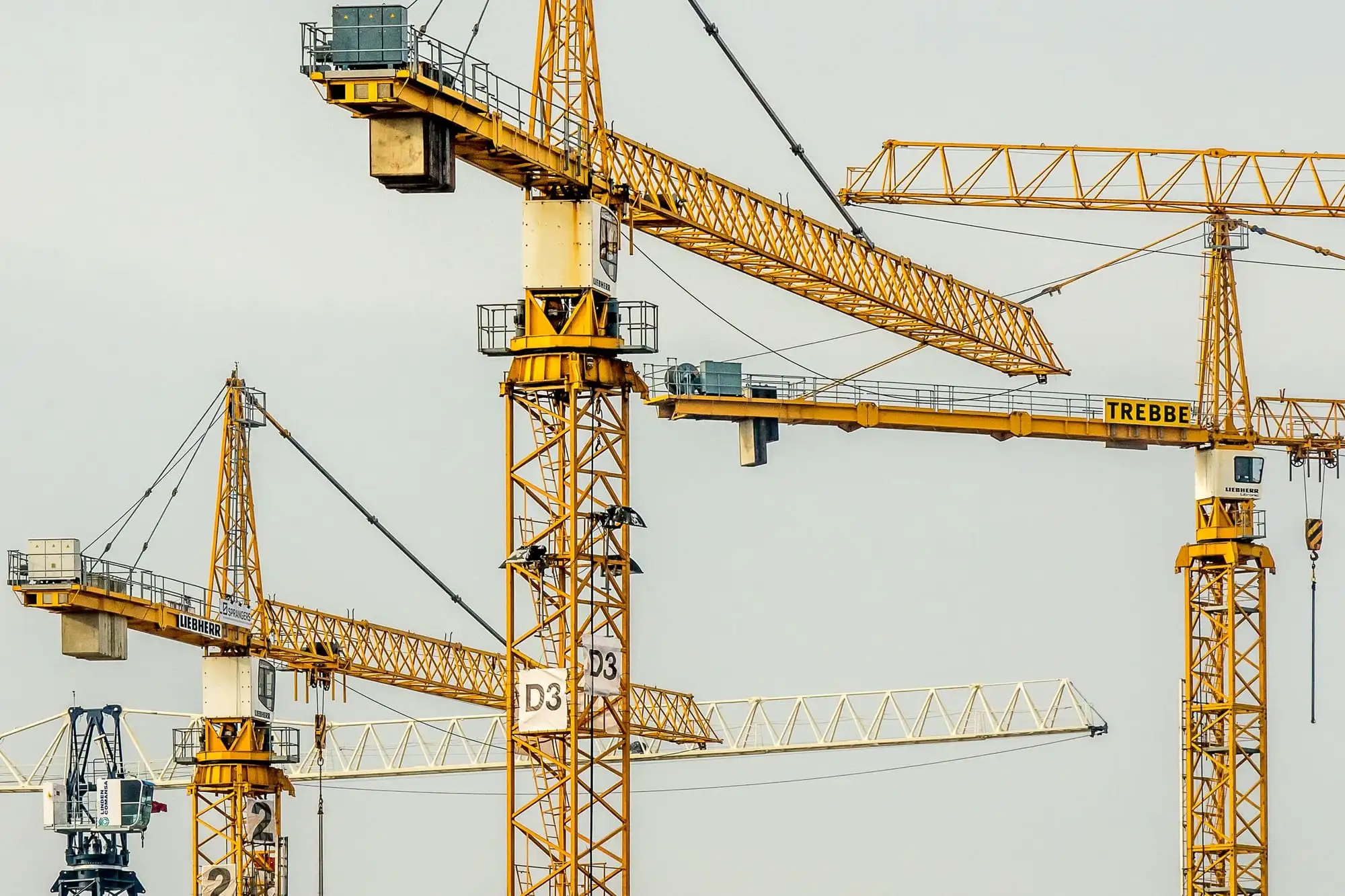 Gule tårnkraner over en byggeplads